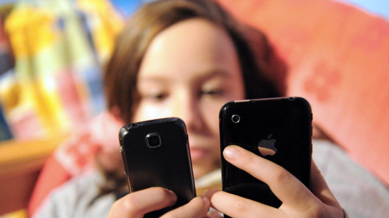 Una niña envía mensajes de texto desde un teléfono móvil. Imagen de archivo. (Denis Charlet / AFP vía Getty Images)