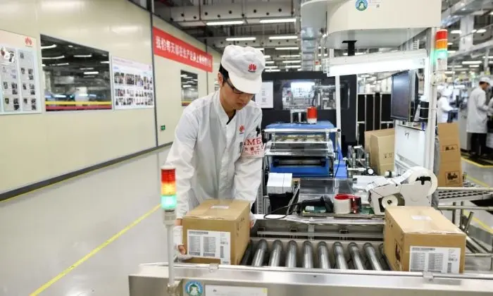 Un empleado trabaja en una línea de producción de teléfonos móviles en una planta de Huawei durante una visita de los medios de comunicación en la ciudad de Dongguan, provincia de Guangdong, China, el 6 de marzo de 2019. (WANG ZHAO/AFP/Getty Images)

