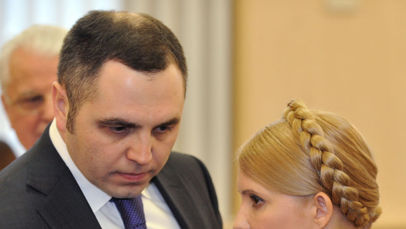 La primera ministra de Ucrania, Yulia Tymoshenko, habla con su representante, Andrey Portnov (izq.), durante una audiencia en el Tribunal Supremo Administrativo de Kiev el 19 de febrero de 2010. (Sergey Supinsky/AFP vía Getty Images).