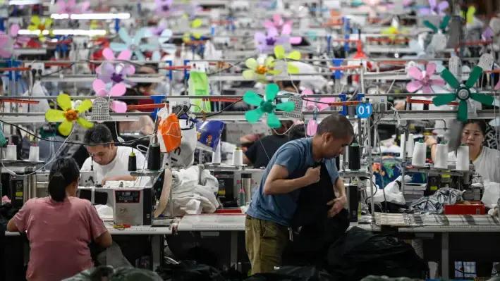 Trabajadores producen prendas en una fábrica textil que abastece a la empresa de comercio electrónico de moda rápida Shein, en Cantón, provincia de Guangdong, China, el 11 de junio de 2024. (Jade Gao/AFP vía Getty Images)

