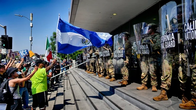 Un manifestante ondea la bandera nacional de El Salvador frente a una línea de la Guardia Nacional de California frente al Edificio Federal el lunes 9 de junio de 2025, en el centro de Los Ángeles. Foto AP/Eric Thayer

