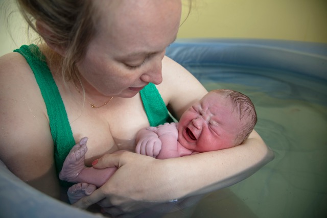 Una nueva madre abrazando a su bebé recién nacido después de un parto natural. Foto de Shutterstock, Inc.