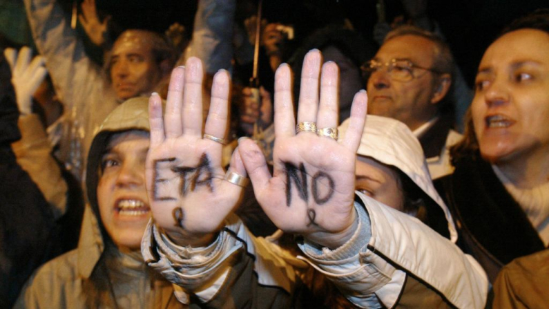 Una joven muestra sus manos marcadas con "Eta, no" denunciando a la organización separatista ETA durante una manifestación contra el terrorismo, en memoria de las víctimas de los atentados ferroviarios ocurridos un día antes, el jueves 12 de marzo de 2004 en Madrid. (PHILIPPE DESMAZES/AFP vía Getty Images)