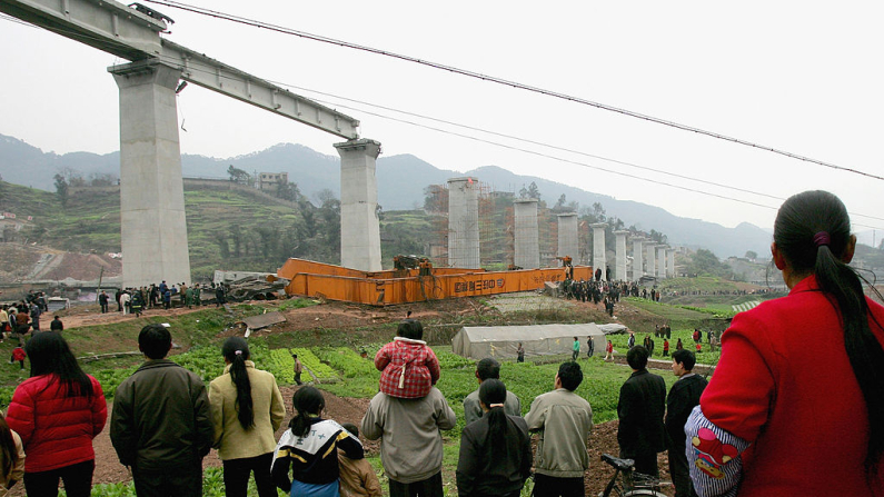 Una multitud se congrega para observar cómo los rescatistas buscan a los trabajadores atrapados tras el derrumbe de una viga de soporte en un proyecto de construcción de un puente ferroviario en Chongqing, China. Imagen de archivo. Foto: China Photos/Getty Images