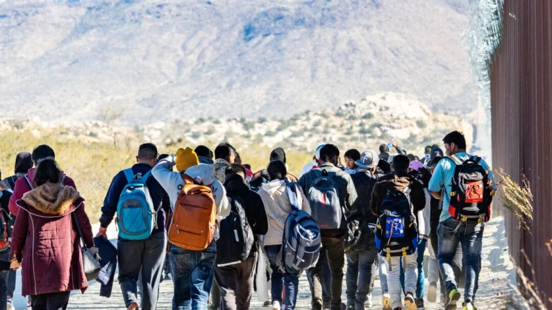 Inmigrantes indocumentados esperan ser procesados por agentes de la Patrulla Fronteriza de EE. UU. en las afueras de San Diego, California, el 5 de diciembre de 2023. John Fredricks/The Epoch Times