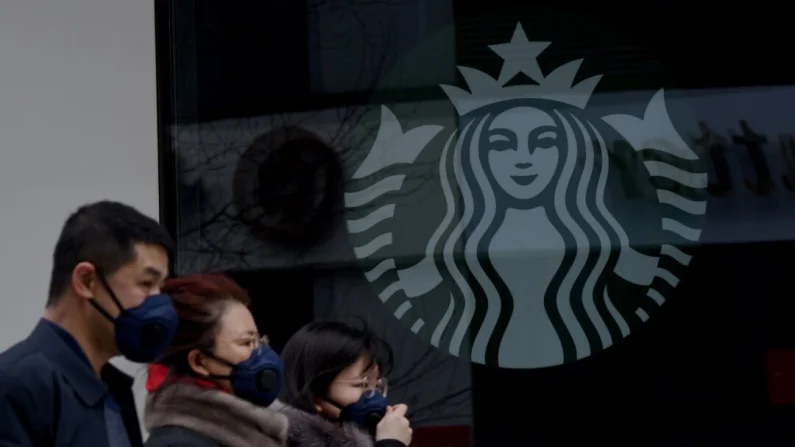 Personas con mascarillas protectoras pasan frente a una cafetería Starbucks cerrada en un supermercado de Pekín el 29 de enero de 2020. Noel Celis/AFP vía Getty Images