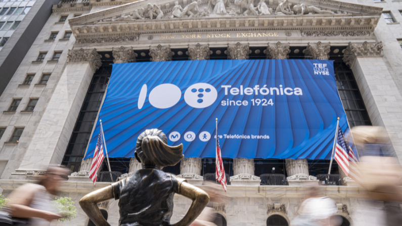 Imagen de archivo de la icónica estatua de "La niña sin miedo" de Wall Street ante una lona que celebraba los 100 años de Telefónica en la fachada de la bolsa de valores de Nueva York (NYSE) en Wall Street, Nueva York (EE. UU). (EFE/Ángel Colmenares)