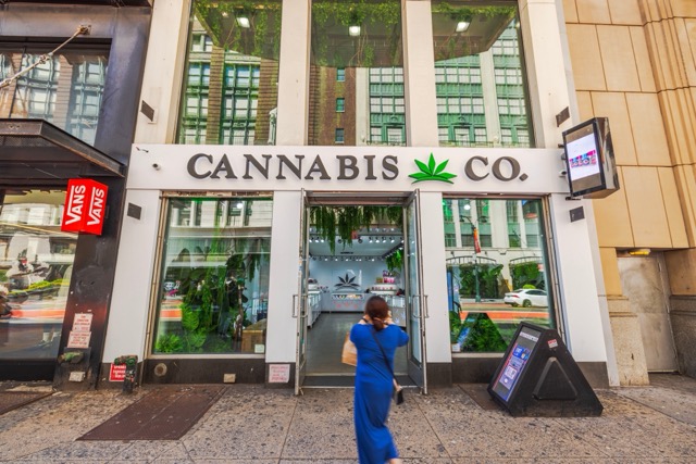 Tienda Cannabis Co con puertas abiertas y peatón vestido azul en la Nueva York. EE.UU. Nueva York. 03 de septiembre de 2025.