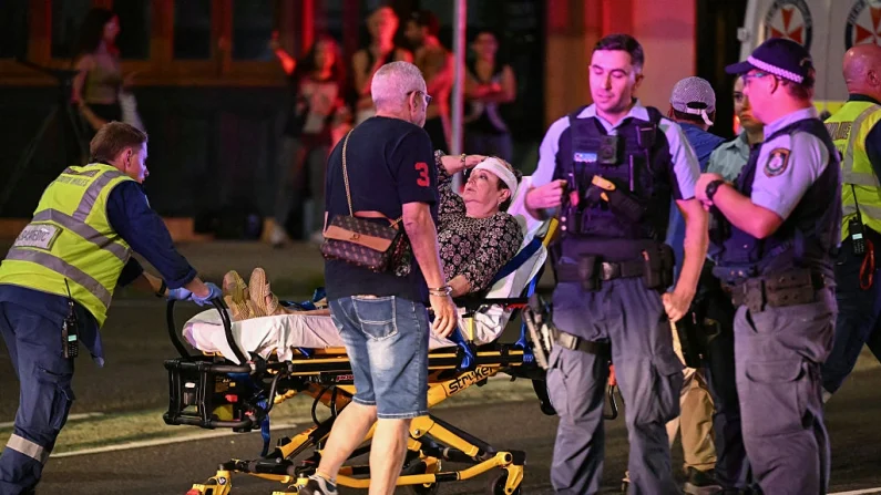 Personal sanitario traslada en camilla a una mujer a una ambulancia tras el atentado terrorista en Bondi Beach, en Sídney (Australia), el 14 de diciembre de 2025. Saeed KHAN/AFP vía Getty Images